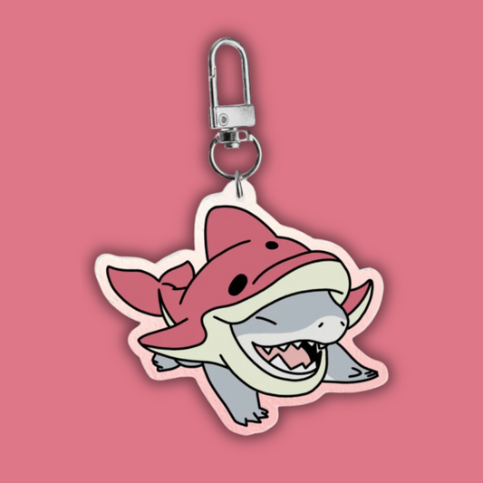Jeff the Land Shark in a pink dolphin outfit keychain on a pink background