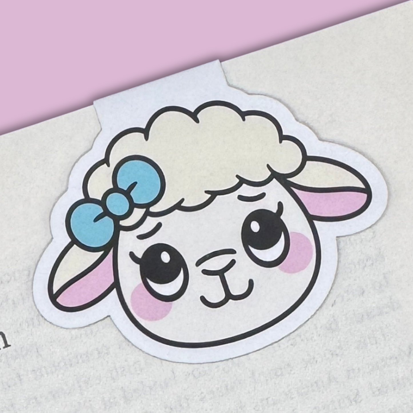 Cartoon sheep magnetic bookmark with a blue bow on a book with a pink background