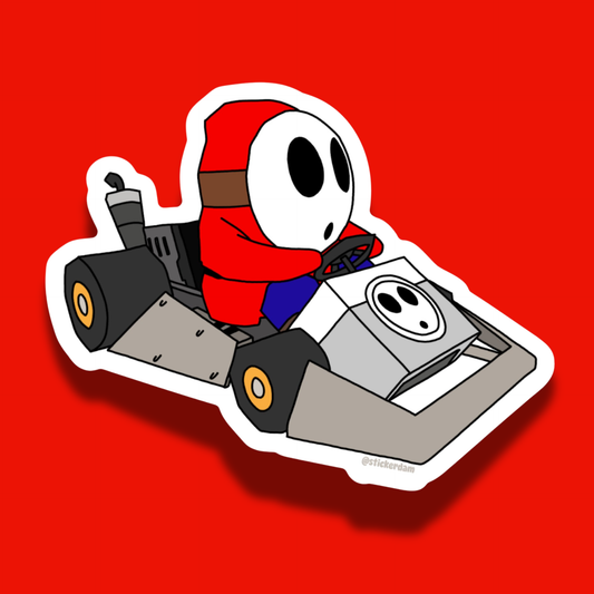 Shy Guy in a racing kart on a red background